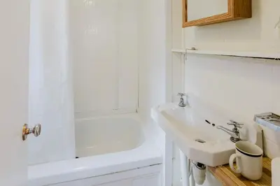 a white bathroom with a sink and a shower at 2-Bedroom Cottage #5 - Lodgepole Pine in Gravenhurst
