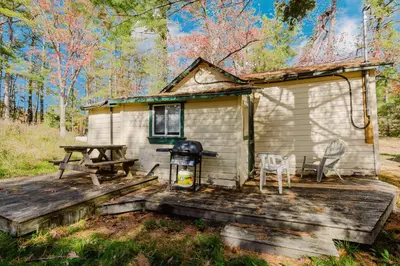 a tiny house with a picnic table and a grill at 1-Bedroom Cottage #1 - White Pine in Gravenhurst