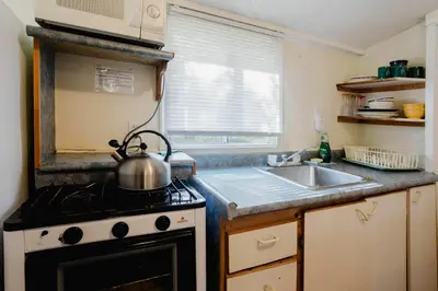a small kitchen with a stove and a sink at 1-Bedroom Cottage #1 - White Pine in Gravenhurst