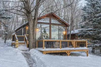 a cabin in the snow with a large window at Lake Muskoka 2-bedroom Cottage - Pier 100 #50 in Port Carling