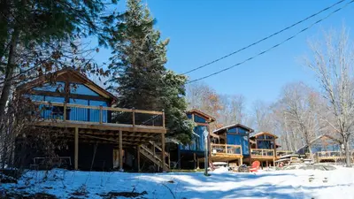 a log cabin in the winter with snow on the ground at Lake Muskoka 2-bedroom Cottage - Pier 100 #50 in Port Carling