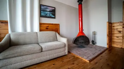 a living room with a couch and a red fireplace at Lake Muskoka 2-bedroom Cottage - Pier 100 #50 in Port Carling