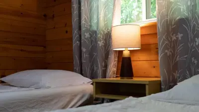 a bedroom with two beds and a lamp on a night stand at Lake Muskoka 3-bdrm Cottage - Pier 100 #70 in Port Carling