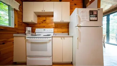 a kitchen with white appliances and wooden walls at Lake Muskoka 3-bdrm Cottage - Pier 100 #70 in Port Carling