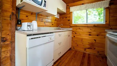 a kitchen with white appliances and wooden walls at Lake Muskoka 3-bdrm Cottage - Pier 100 #70 in Port Carling