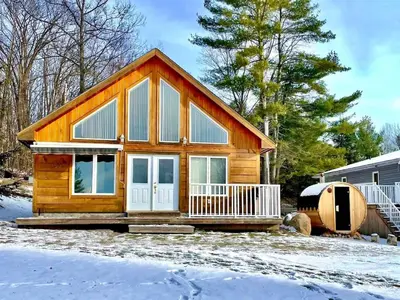 a small log cabin in the snow at Muskoka Lakefront 3-bdrm Chalet #90 in Port Carling