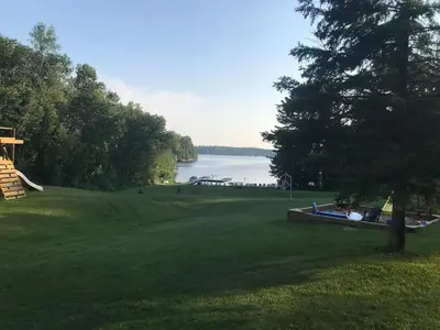 a grassy field with a lake in the background at Muskoka Lakefront 3-bdrm Chalet #90 in Port Carling