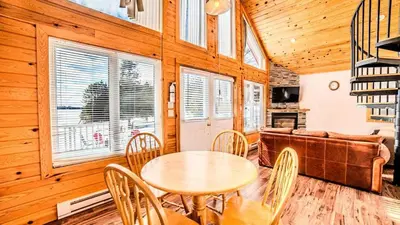 a dining room with a table and chairs and a couch at Muskoka Lakefront 3-bdrm Chalet #90 in Port Carling