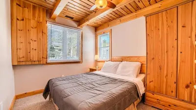 a bedroom with a bed in a room with wooden walls at Muskoka Lakefront 3-bdrm Chalet #90 in Port Carling