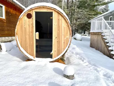a wooden sauna in the snow next to a house at Muskoka Lakefront 3-bdrm Chalet #90 in Port Carling