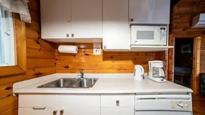 a kitchen with a sink and a microwave at Muskoka Lakeview Cottage - Pier 100 #40 in Port Carling