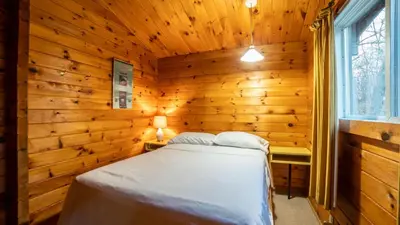 a bedroom with a bed in a wooden room at Muskoka Lakeview Cottage - Pier 100 #40 in Port Carling
