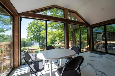 a room with a table and chairs and windows at Lake Muskoka Deluxe 2-bdrm Cottage - Pier 100 #60 in Port Carling