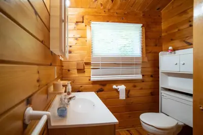 a bathroom with a sink and a toilet and a window at Lake Muskoka 3-bedroom Cottage - Pier 100 #30 in Port Carling