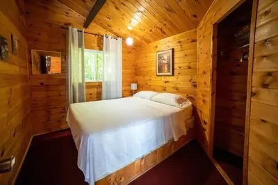 a bedroom with a bed in a log cabin at Lake Muskoka 3-bedroom Cottage - Pier 100 #30 in Port Carling