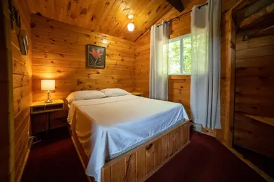 a bedroom with a bed in a log cabin at Lake Muskoka 3-bedroom Cottage - Pier 100 #30 in Port Carling