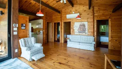 a living room with two chairs and a kitchen at Lake Muskoka 3-bedroom Cottage - Pier 100 #30 in Port Carling