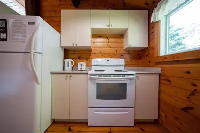 a kitchen with a white stove and a refrigerator at Lake Muskoka 3-bedroom Cottage - Pier 100 #30 in Port Carling