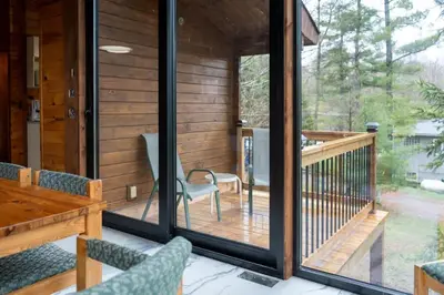 a screened in porch with chairs and a table at Lake Muskoka Deluxe 3-bdrm Cottage - Pier 100 #80 in Port Carling