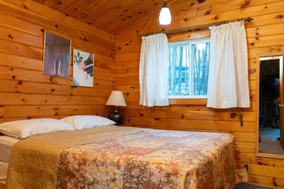 a bedroom with a bed in a log cabin at Lake Muskoka Deluxe 3-bdrm Cottage - Pier 100 #80 in Port Carling