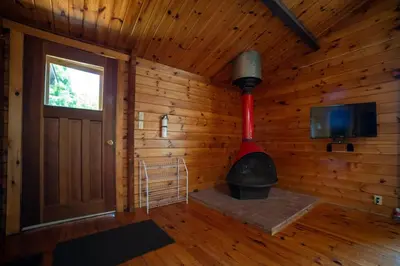 a room with a woodburning stove in a cabin at Lake Muskoka 3-bedroom Cottage - Pier 100 #20 in Port Carling