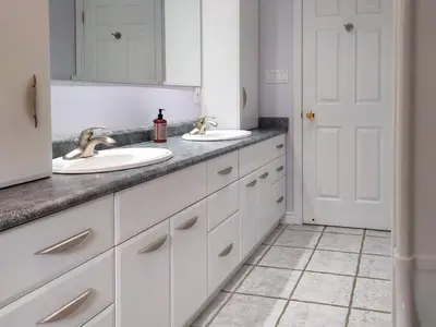 a white bathroom with two sinks and a mirror at Muskoka Lakefront 4-bdrm Guest House in Port Carling
