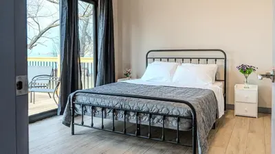 a bedroom with a bed and a balcony at 2-bedroom Lake Front Cottage in Harwood ON #6 in Harwood