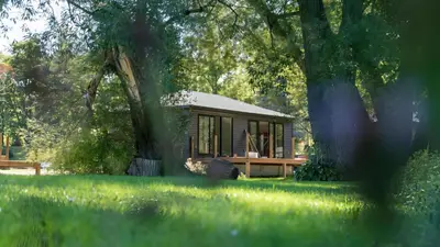 a small house in the middle of a grass field at 2-bedroom Lake Front Cottage in Harwood ON #6 in Harwood