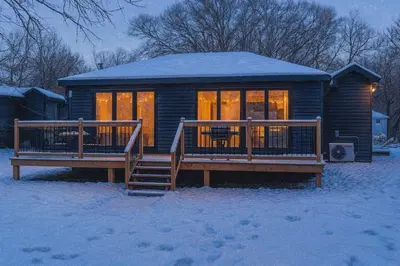 a log cabin with a deck in the snow at 2-bedroom Lake Front Cottage in Harwood ON #4 in Harwood