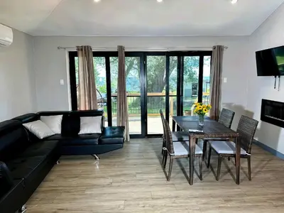 a living room with a black couch and a table at 2-bedroom Lake Front Cottage in Harwood ON #4 in Harwood