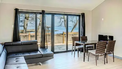 a living room with a couch and a table at 2-bedroom Lake Front Cottage in Harwood ON #4 in Harwood