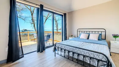 a bedroom with a bed and a balcony at 2-bedroom Lake Front Cottage in Harwood ON #4 in Harwood