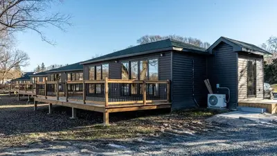 a house with a large deck on the side of it at 2-bedroom Lake Front Cottage in Harwood ON #4 in Harwood