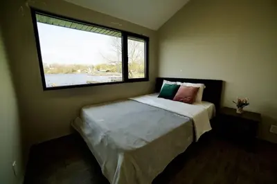 a bedroom with a bed with a large window at 1-bedroom Townhouse in Harwood #2 in Harwood