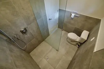 a bathroom with a toilet and a glass shower at 1-bedroom Townhouse in Harwood #3 in Harwood