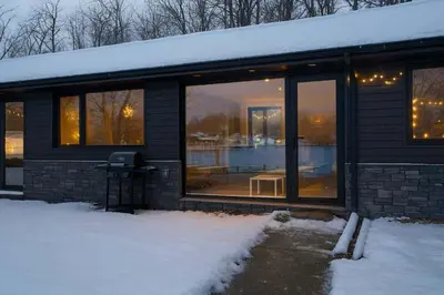 a house with glass windows in the snow at 1-bedroom Townhouse in Harwood #5 in Harwood
