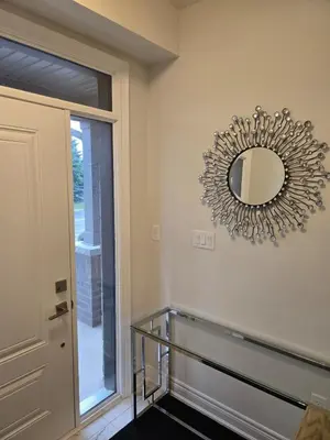 a mirror hanging on a wall next to a door at Modern 4 Bedroom Home -Oakville in Oakville