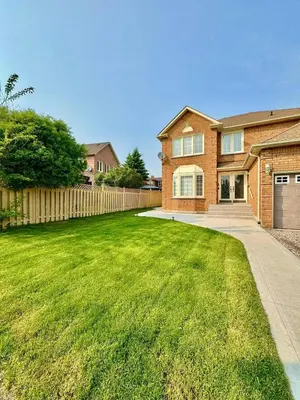 a brick house with a fence and a yard at 2 BR Private Basement Suite | Minutes from YYZ in Brampton
