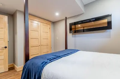 a bedroom with a large white bed and a closet at Lakefront cottage with golf area BBQ pool table in Bobcaygeon