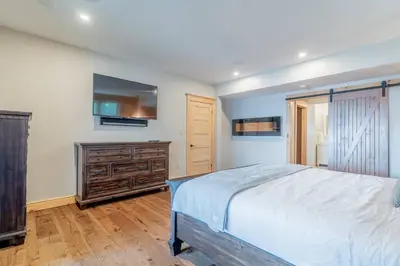 a bedroom with a large bed and a wooden dresser at Lakefront cottage with golf area BBQ pool table in Bobcaygeon