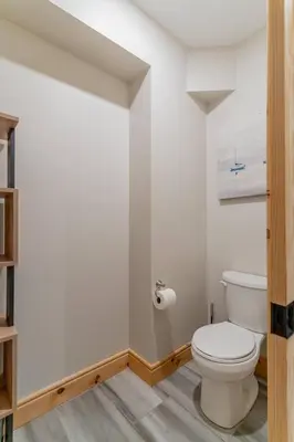 a bathroom with a toilet and a toilet paper dispenser at Lakefront cottage with golf area BBQ pool table in Bobcaygeon
