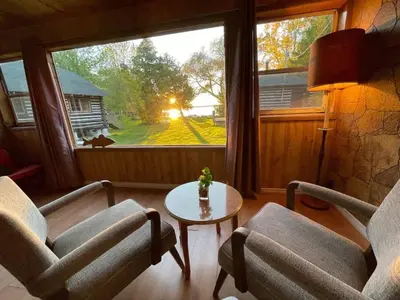 a living room with two chairs and a table and a window at Balsam Lake - 2-Bedroom Cottage #8 in Kawartha Lakes