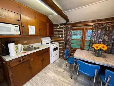 a kitchen with a sink and a table with chairs at Balsam Lake - 2-Bedroom Cottage #8 in Kawartha Lakes