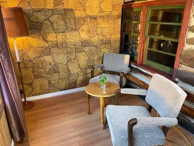 a room with two chairs and a table and a stone wall at Balsam Lake - 2-Bedroom Cottage #8 in Kawartha Lakes