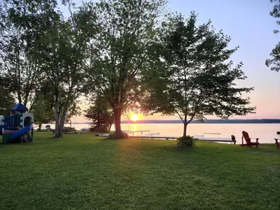 a park with trees and benches and the water at Balsam Lake - 2-Bedroom Cottage #8 in Kawartha Lakes