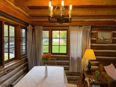 a dining room with a table and some windows at 2-Bedroom - Balsam Lake Cottages Resort #12 in Kawartha Lakes