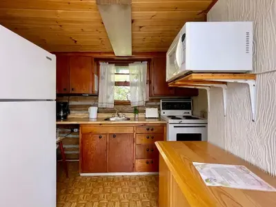 a kitchen with wooden cabinets and a white refrigerator at 1-Bedroom Balsam Lake Cottage #9 in Kawartha Lakes