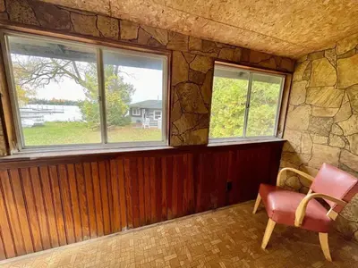a room with two windows and a chair in it at 1-Bedroom Balsam Lake Cottage #9 in Kawartha Lakes