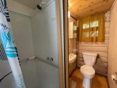a small bathroom with a toilet and a shower at 1-Bedroom Balsam Lake Cottage #9 in Kawartha Lakes