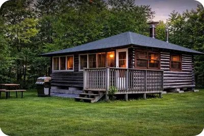 a log cabin with a porch and a picnic table at 1-Bedroom Balsam Lake Cottage #9 in Kawartha Lakes